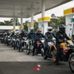Long line of motorcycle riders refueling at a gas station in the Philippines during the fuel crisis showing motorcycles as transportation solution