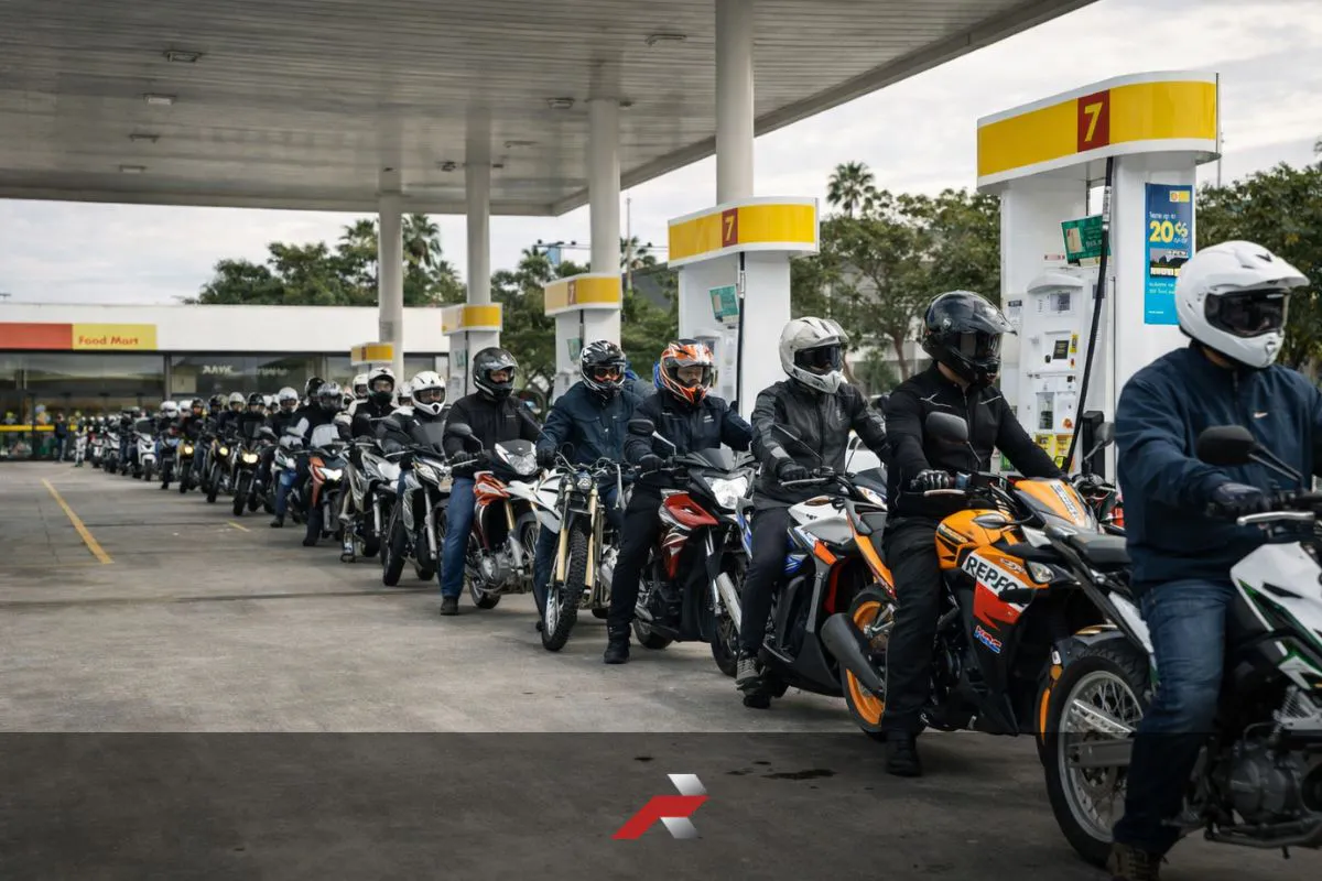 Long line of motorcycle riders refueling at a gas station in the Philippines during the fuel crisis showing motorcycles as transportation solution