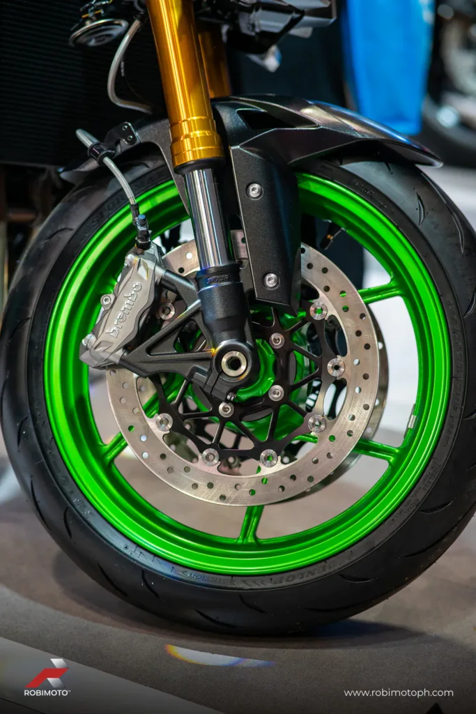 Kawasaki Z1100 SE 2026 front wheel showing Brembo brake caliper, dual disc rotor, and green alloy rim at Makina Moto Show
