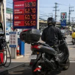 Scooter rider refueling at a gasoline station in heavy Philippine traffic showing real world fuel efficiency conditions