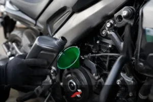 Close-up of big bike engine oil being added to a Dominar-style motorcycle during maintenance