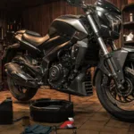 Big bike oil change service in a garage with a Dominar-style motorcycle, oil drain pan, tools, and maintenance supplies