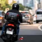 Stainless acrylic motorcycle backplates featured image showing a rider leaning slightly on a city road with a shiny rear plate area and unreadable plate number