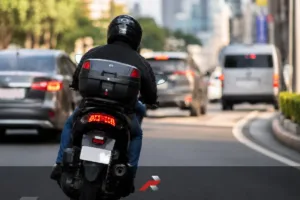 Stainless acrylic motorcycle backplates featured image showing a rider leaning slightly on a city road with a shiny rear plate area and unreadable plate number