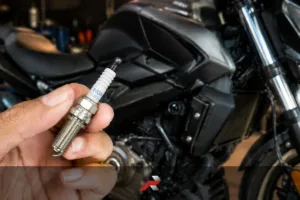 Dominar 400 spark plug replacement cost Philippines shown with NGK iridium spark plug and motorcycle background